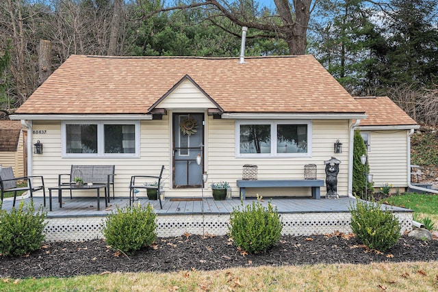 view of front of property with a shingled roof and a deck