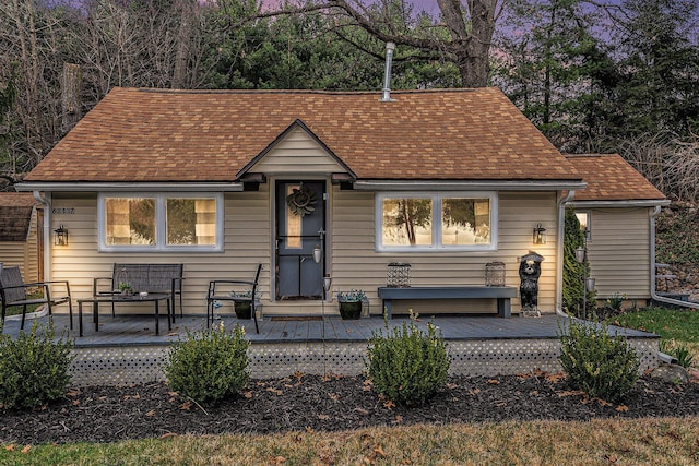 view of front of home with a shingled roof and a wooden deck
