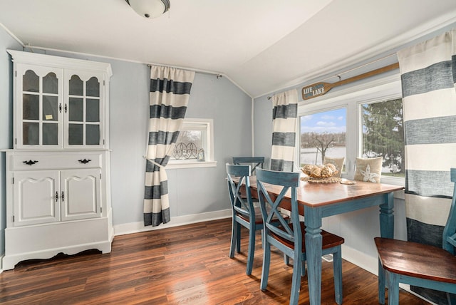 dining space with dark wood-type flooring, baseboards, and vaulted ceiling
