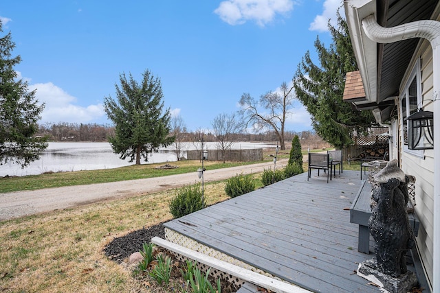 deck with a water view and a yard