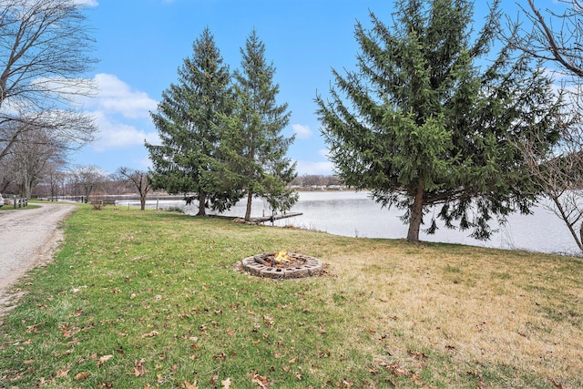 view of yard featuring a water view and a fire pit