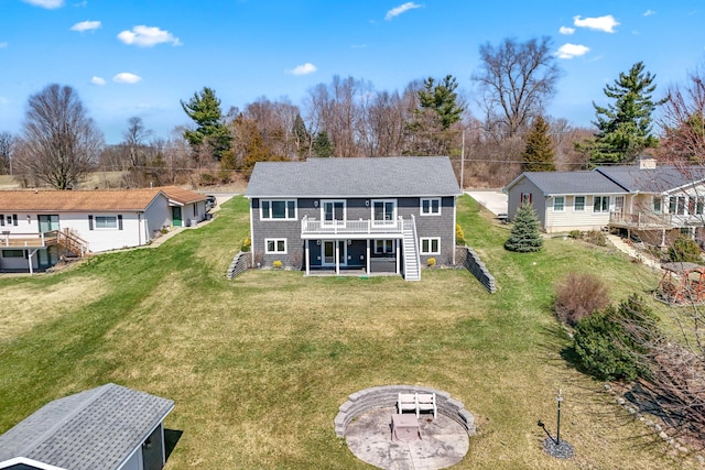 rear view of property featuring a lawn, stairs, a fire pit, and a wooden deck