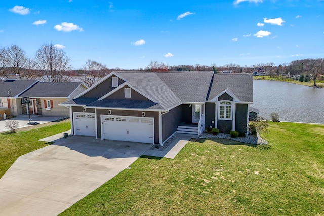 view of front facade featuring driveway, a front yard, an attached garage, a shingled roof, and a water view
