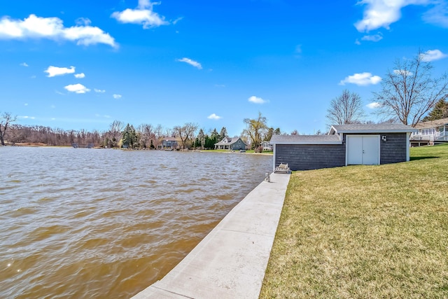 view of dock with a lawn and a water view