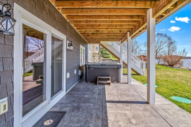 view of patio / terrace with a hot tub and stairway