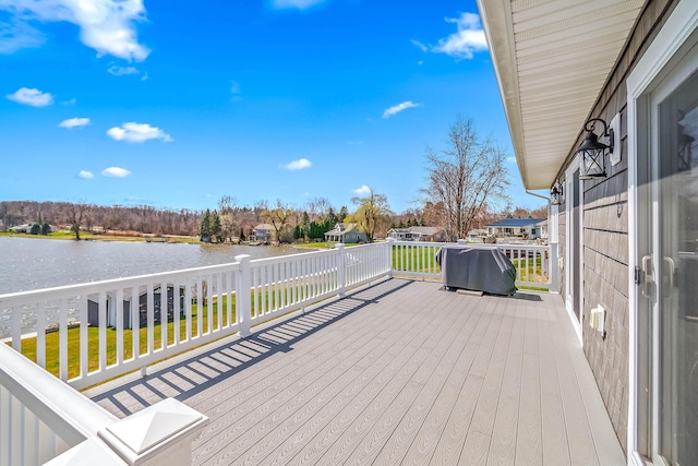 wooden terrace with a lawn and a water view