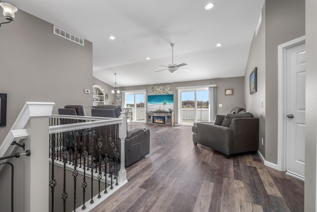 living area with lofted ceiling, recessed lighting, visible vents, a ceiling fan, and wood finished floors