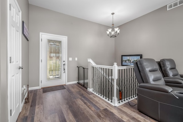 foyer featuring dark wood-style flooring, baseboards, a chandelier, and visible vents