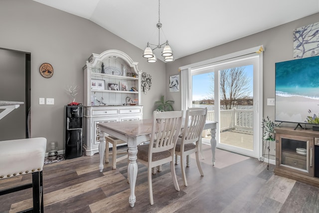 dining space featuring vaulted ceiling, wood finished floors, and a chandelier
