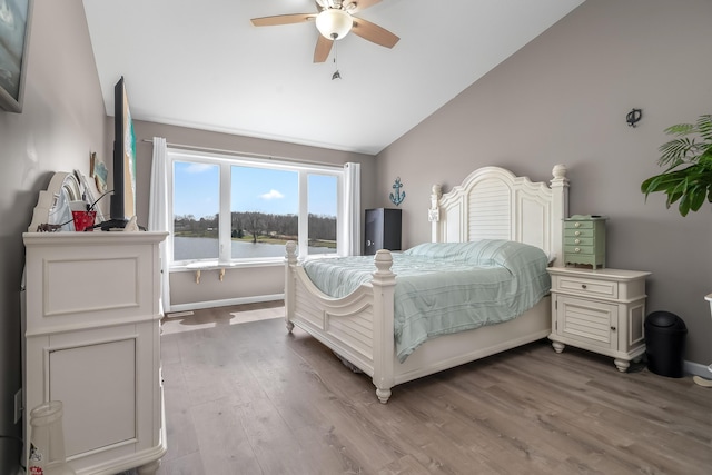 bedroom with baseboards, lofted ceiling, wood finished floors, and a ceiling fan