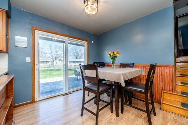 1373 Kingman Dr, Saint Joseph, MI 49085 - dining room featuring a wainscoted wall, light wood-style floors, and wood walls