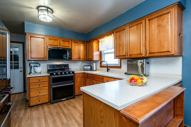 1373 Kingman Dr, Saint Joseph, MI 49085 - kitchen with black appliances, a peninsula, a sink, and brown cabinetry
