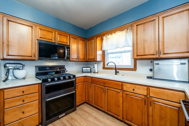 1373 Kingman Dr, Saint Joseph, MI 49085 - kitchen with a sink, light countertops, black microwave, and double oven range