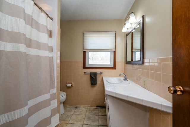 1373 Kingman Dr, Saint Joseph, MI 49085 - bathroom with a wainscoted wall, tile patterned floors, toilet, vanity, and tile walls