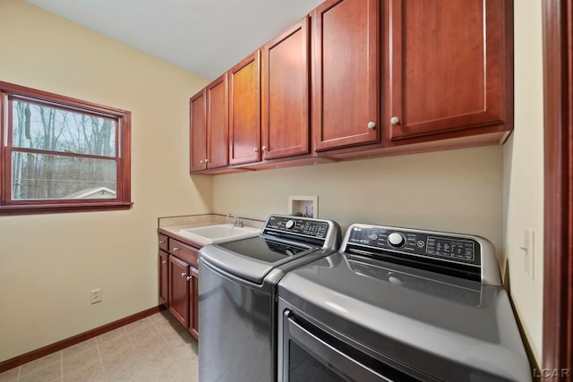 washroom with cabinet space, separate washer and dryer, baseboards, and a sink