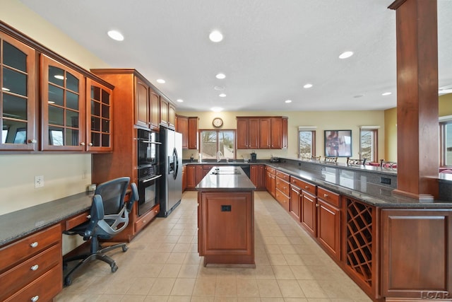 kitchen with stainless steel fridge, recessed lighting, a sink, and a center island