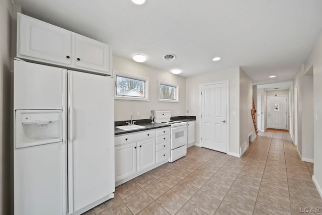 3387 Round Lake Hwy, Manitou Beach, MI 49253 - kitchen with white appliances, dark countertops, white cabinets, recessed lighting, and light tile patterned flooring