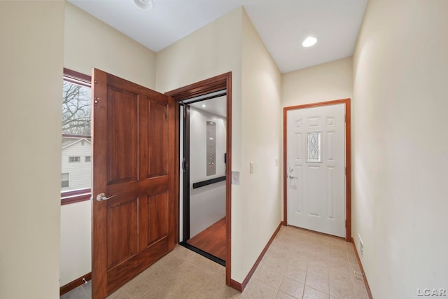 foyer featuring baseboards, light tile patterned flooring, and visible vents