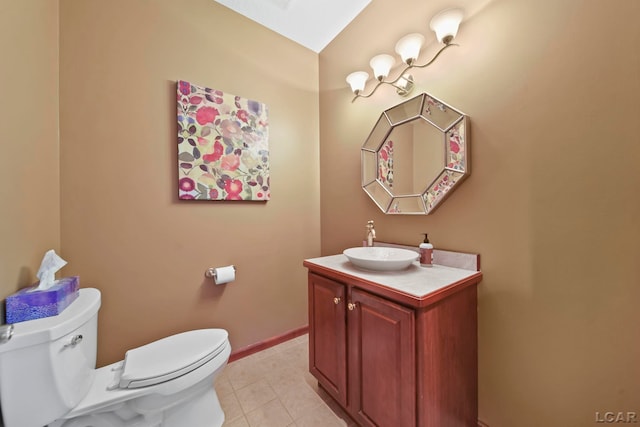 half bath with toilet, tile patterned floors, baseboards, and vanity