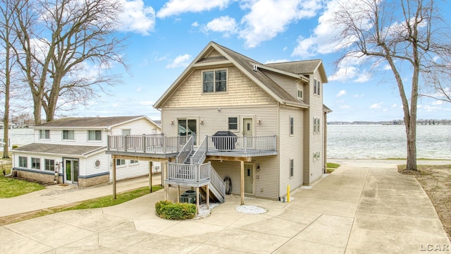 view of front of property featuring stairs and a deck with water view