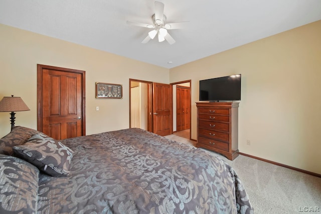 bedroom featuring baseboards, light carpet, ceiling fan, and a closet
