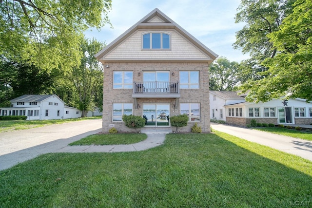 3387 Round Lake Hwy, Manitou Beach, MI 49253 - view of front facade with a front yard, a balcony, brick siding, and driveway
