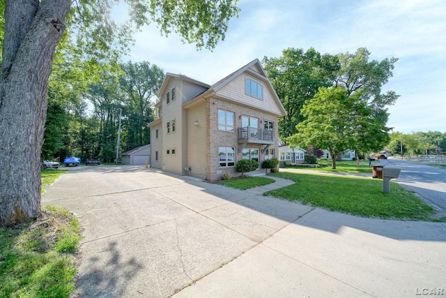 3387 Round Lake Hwy, Manitou Beach, MI 49253 - view of front of home featuring a front yard, a balcony, brick siding, a garage, and driveway