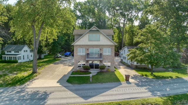3387 Round Lake Hwy, Manitou Beach, MI 49253 - view of front of property featuring concrete driveway, a front yard, view of wooded area, brick siding, and a porch
