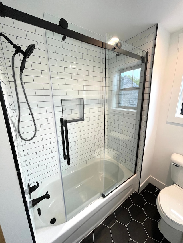 2323 Canterwood, Highland, MI 48357 - full bath featuring toilet, baseboards, bath / shower combo with glass door, and tile patterned floors