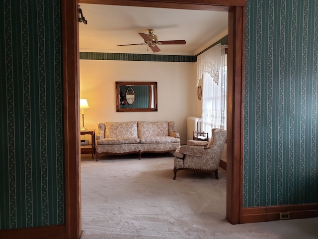 sitting room with carpet floors, ceiling fan, and wallpapered walls