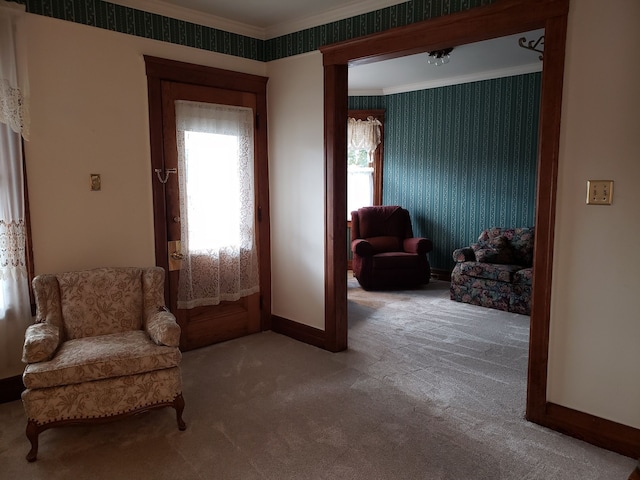 sitting room with baseboards, crown molding, carpet, and wallpapered walls