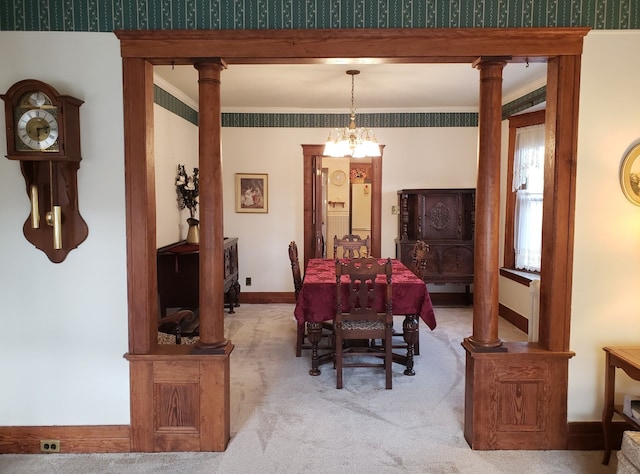dining area with crown molding, baseboards, decorative columns, light carpet, and an inviting chandelier