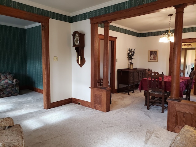 interior space with baseboards, ornamental molding, an inviting chandelier, and decorative columns