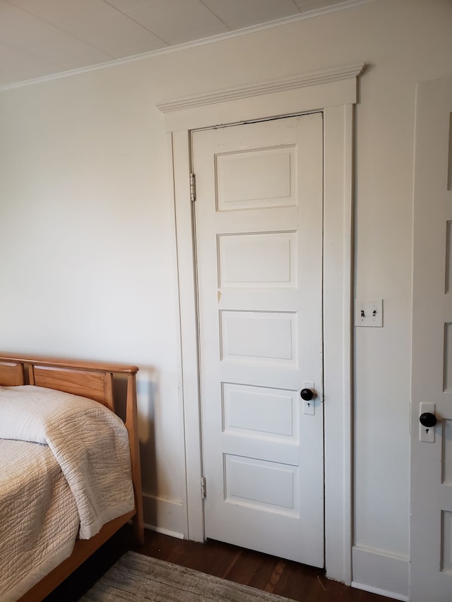 bedroom featuring dark wood-style flooring and crown molding