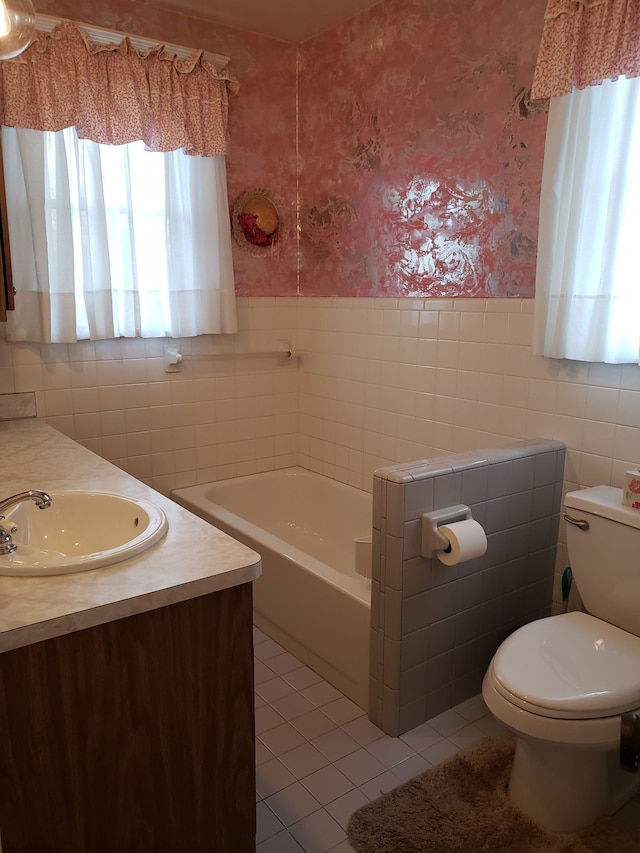bathroom with toilet, wainscoting, tile patterned flooring, a bathtub, and wallpapered walls