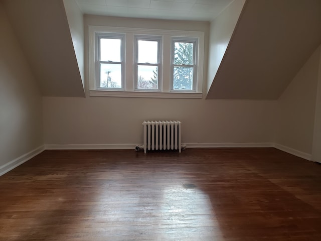 bonus room featuring baseboards, dark wood-style flooring, lofted ceiling, and radiator heating unit