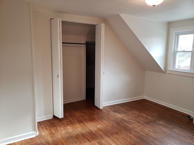 interior space featuring baseboards, vaulted ceiling, and wood-type flooring