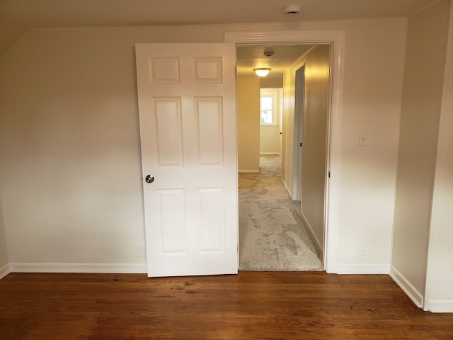 hallway with baseboards, crown molding, and wood finished floors