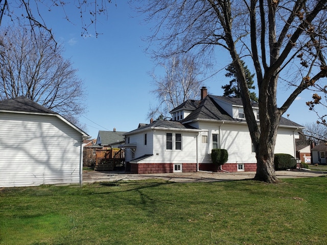 rear view of property featuring a lawn