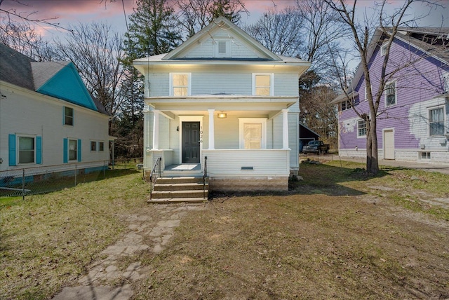 1026 S Jackson St, Jackson, MI 49203 - american foursquare style home featuring a porch, fence, and a front lawn