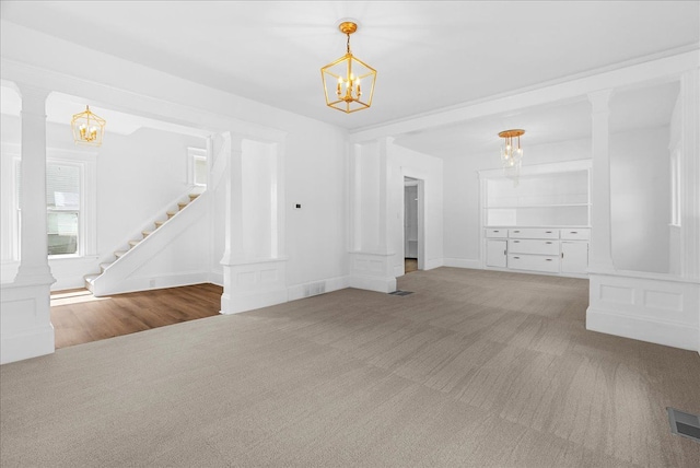 1026 S Jackson St, Jackson, MI 49203 - unfurnished living room with ornate columns, carpet flooring, and a notable chandelier