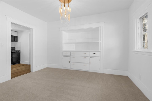 1026 S Jackson St, Jackson, MI 49203 - interior space featuring baseboards, an inviting chandelier, and carpet floors