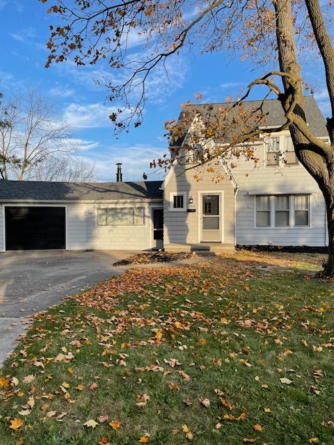 view of front of property featuring driveway, a garage, and a front lawn