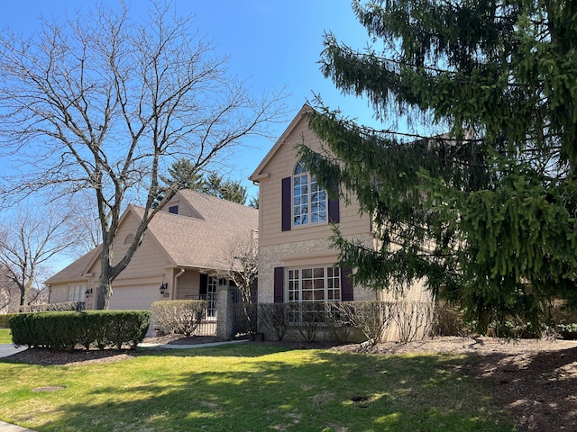 traditional-style home featuring a front lawn and a garage