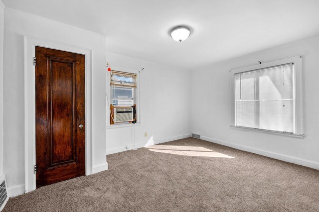 empty room featuring visible vents, carpet floors, and baseboards