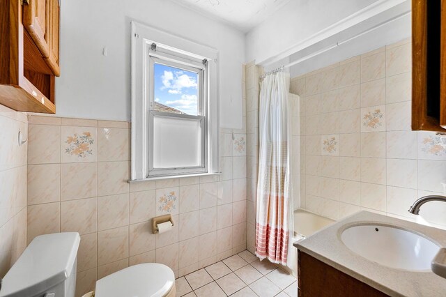 full bath featuring tile walls, tile patterned floors, toilet, and vanity