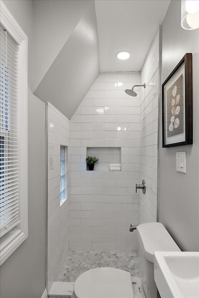 bathroom featuring toilet and tiled shower