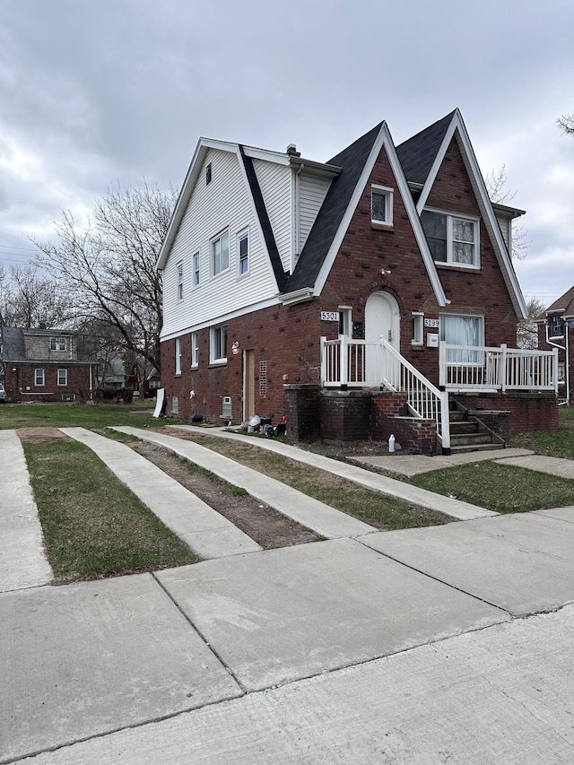 view of front facade featuring a shingled roof and brick siding