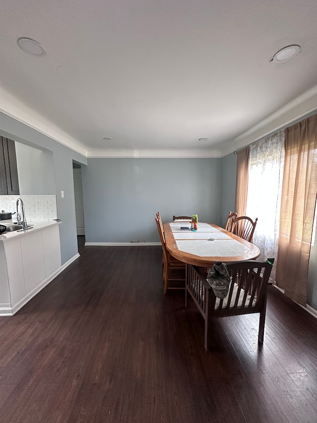 dining space with baseboards and wood finished floors