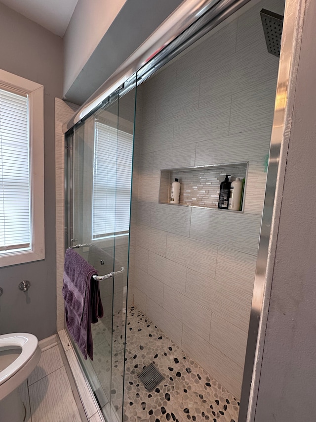 full bath featuring baseboards, toilet, a stall shower, and tile patterned floors